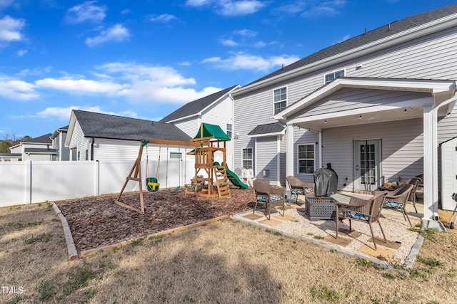 back of house featuring a patio area, fence, and a playground