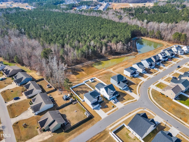 birds eye view of property with a residential view, a water view, and a view of trees