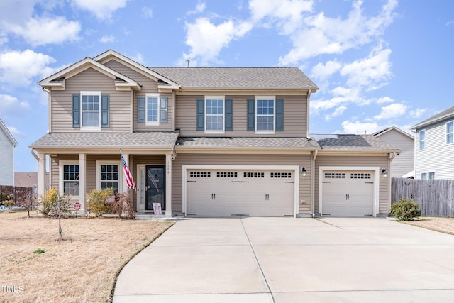 view of front facade with a garage, driveway, a shingled roof, and fence