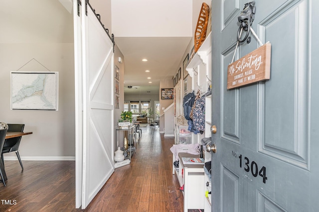 entryway featuring dark wood-style floors, recessed lighting, baseboards, and a barn door