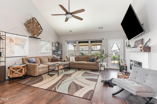 living area featuring visible vents, a ceiling fan, hardwood / wood-style flooring, a fireplace, and high vaulted ceiling