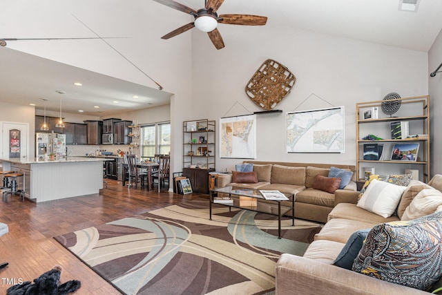 living room featuring ceiling fan, recessed lighting, a high ceiling, visible vents, and dark wood finished floors