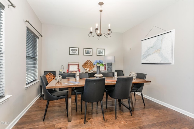 dining room featuring a notable chandelier, baseboards, and wood finished floors