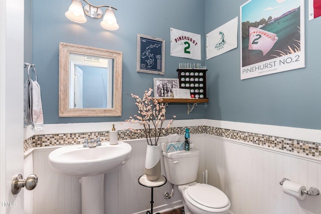 bathroom with wainscoting and toilet