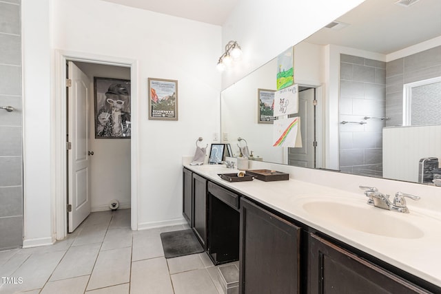 bathroom with a sink, visible vents, a tile shower, tile patterned floors, and double vanity