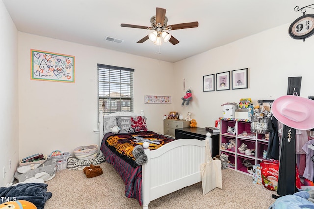 carpeted bedroom with a ceiling fan and visible vents