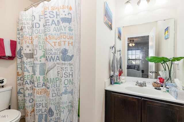 bathroom featuring toilet, a shower with shower curtain, and vanity