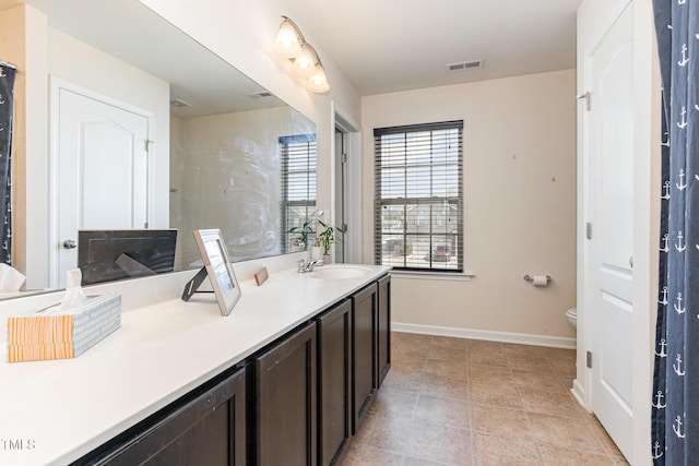 bathroom featuring visible vents, toilet, vanity, and baseboards