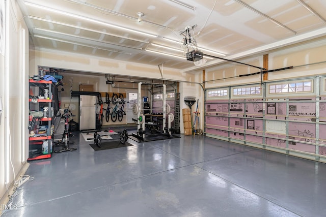 garage with freestanding refrigerator and a garage door opener