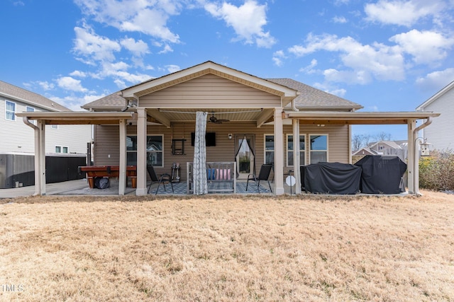 back of property with a ceiling fan, a patio, and a shingled roof