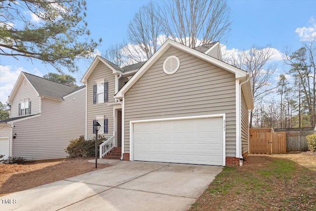 traditional-style home with a garage, driveway, and fence