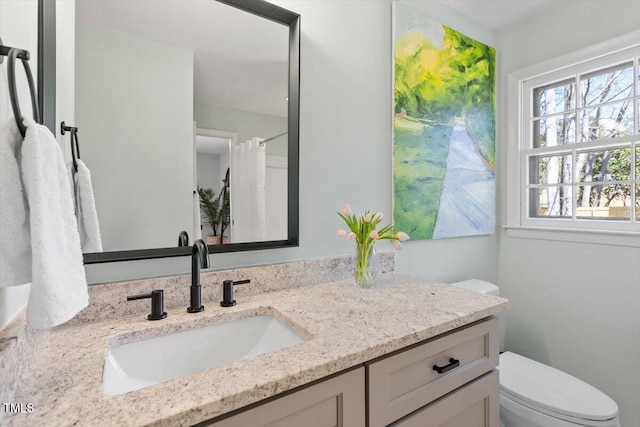 full bathroom with curtained shower, vanity, and toilet