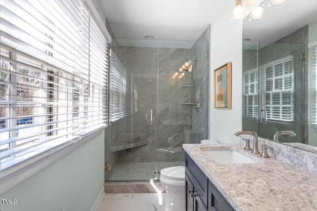 full bath with a stall shower, marble finish floor, vanity, and toilet