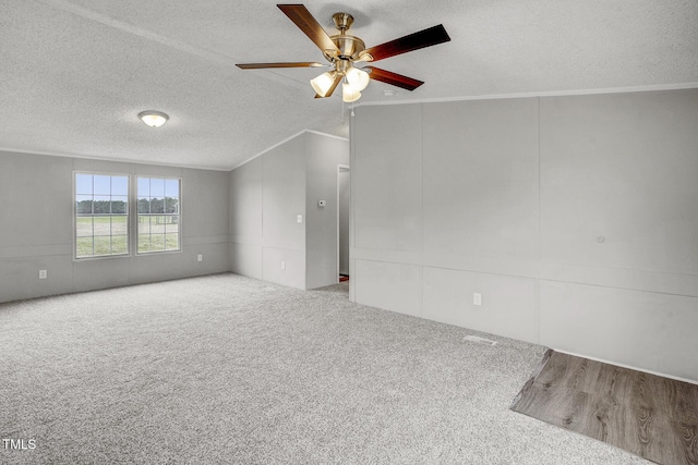 carpeted spare room featuring a textured ceiling, ceiling fan, and ornamental molding