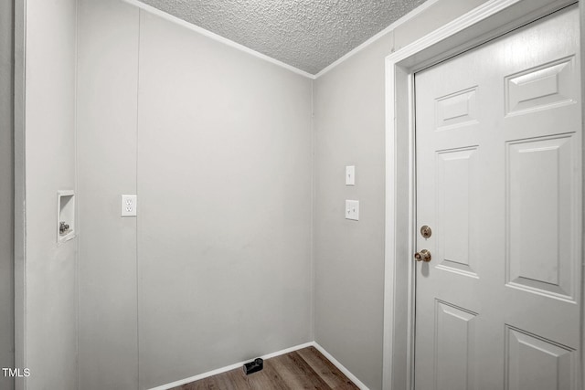 washroom with dark wood-style flooring, hookup for a washing machine, a textured ceiling, laundry area, and baseboards