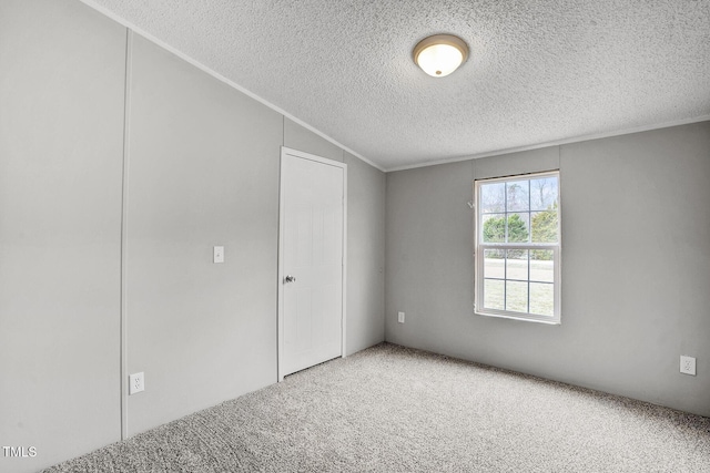 empty room featuring a textured ceiling, ornamental molding, and carpet flooring