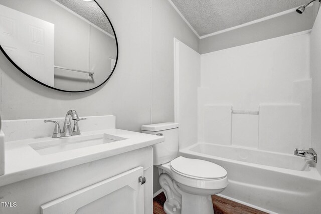 bathroom with a textured ceiling, shower / bathtub combination, toilet, wood finished floors, and vanity