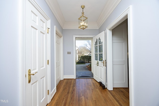 doorway to outside with a chandelier, baseboards, wood finished floors, and crown molding