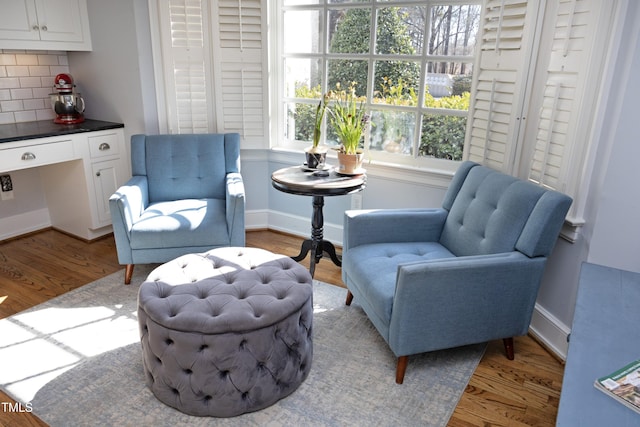 sitting room with baseboards, wood finished floors, and built in study area