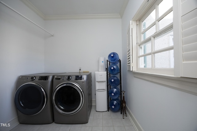 clothes washing area featuring baseboards, separate washer and dryer, laundry area, and crown molding