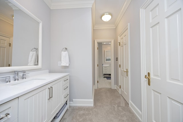 bathroom with vanity, crown molding, and baseboards