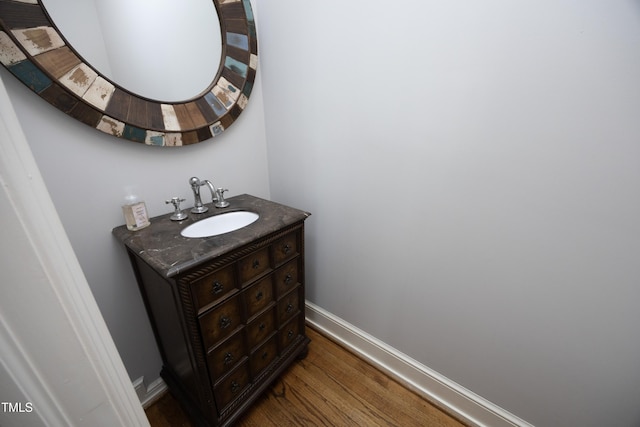 bathroom featuring vanity, baseboards, and wood finished floors