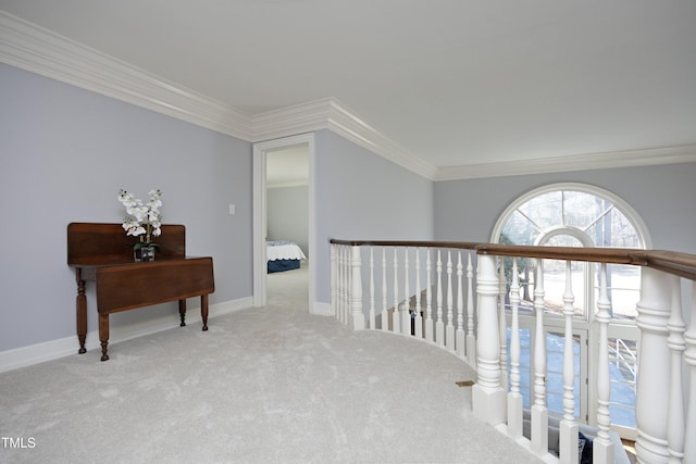 corridor with an upstairs landing, carpet, baseboards, and ornamental molding