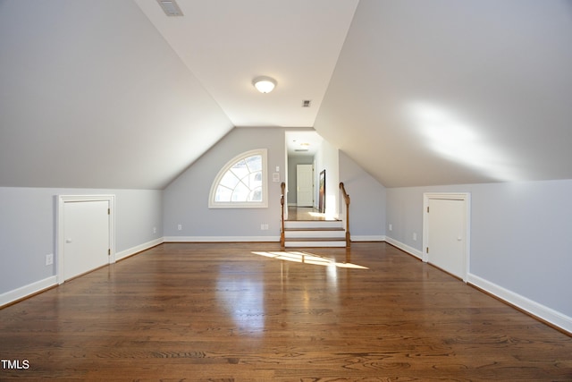 additional living space featuring vaulted ceiling, visible vents, baseboards, and wood finished floors