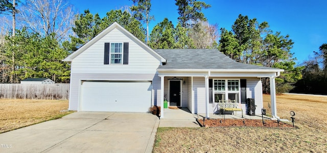 traditional-style house with a front yard, covered porch, an attached garage, and concrete driveway