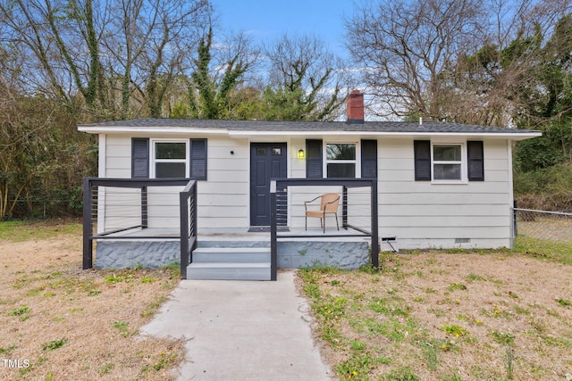 view of front of home featuring covered porch, fence, a chimney, and crawl space