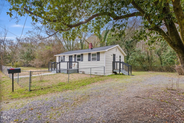 view of front of property featuring fence private yard, a chimney, and crawl space