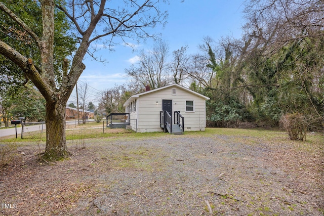 view of outbuilding with entry steps and fence