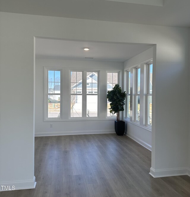 unfurnished room featuring dark wood-style floors and baseboards