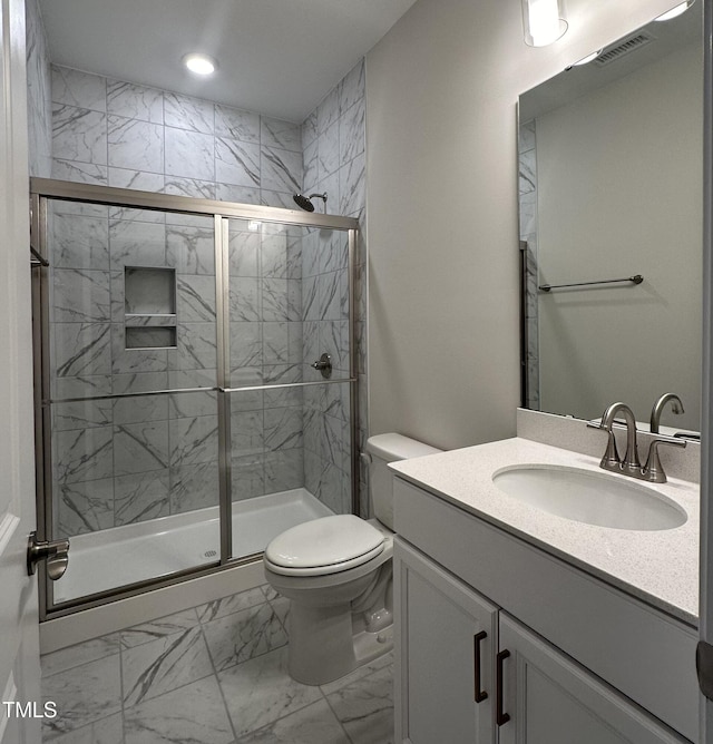 bathroom with marble finish floor, toilet, vanity, visible vents, and a stall shower