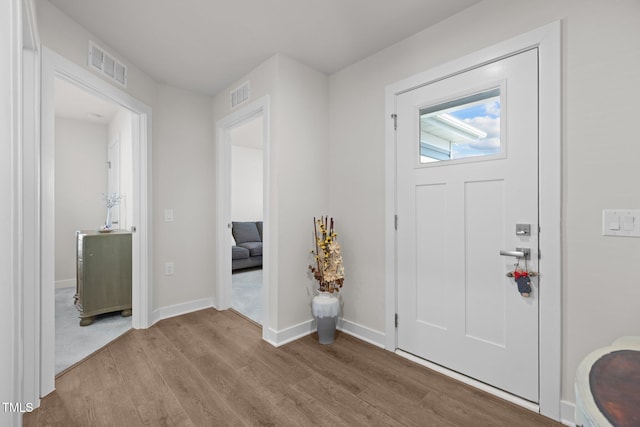 entrance foyer featuring visible vents, baseboards, and wood finished floors