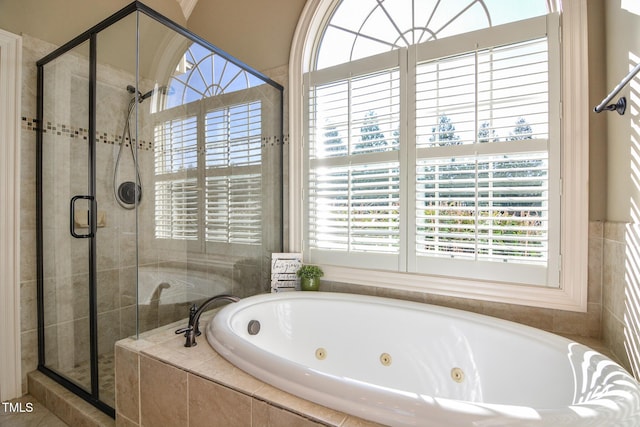 bathroom featuring a tub with jets and a stall shower