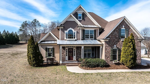 craftsman-style home with a porch, a front yard, a standing seam roof, and brick siding