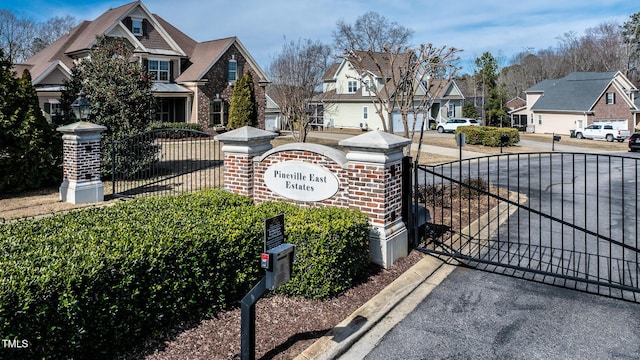 community sign with a residential view and a gate