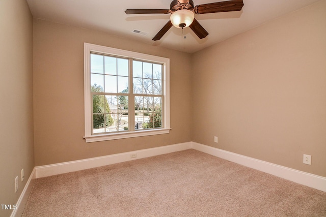 empty room with carpet, visible vents, ceiling fan, and baseboards