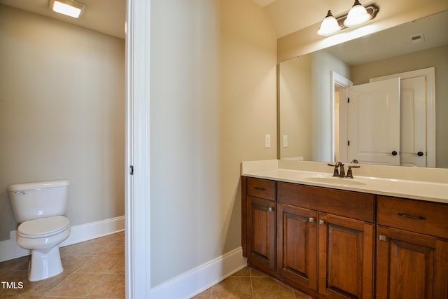 bathroom with toilet, vanity, baseboards, and tile patterned floors