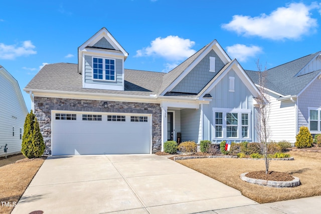 craftsman-style house featuring driveway, stone siding, board and batten siding, a shingled roof, and a garage