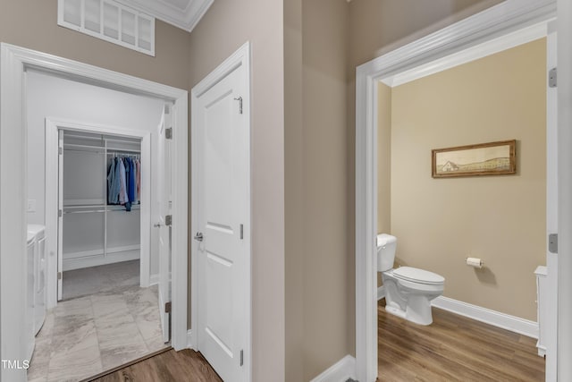 bathroom with visible vents, toilet, marble finish floor, baseboards, and washing machine and clothes dryer