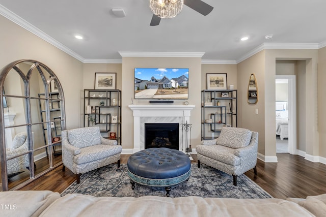 living room with a fireplace, crown molding, baseboards, and wood finished floors