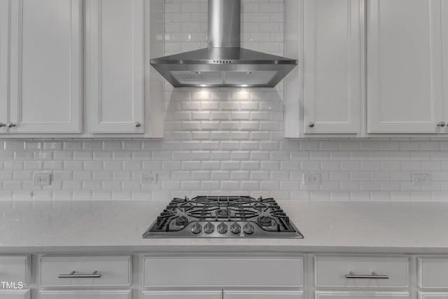 kitchen featuring white cabinetry, wall chimney exhaust hood, gas stovetop, and backsplash