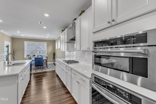 kitchen with tasteful backsplash, stainless steel appliances, crown molding, and a sink