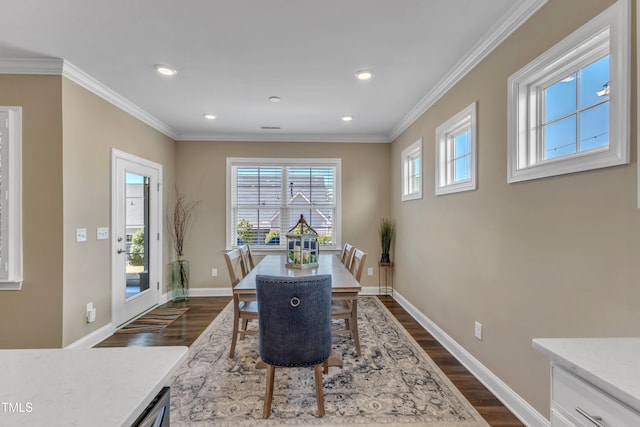 dining space with dark wood finished floors, crown molding, and baseboards