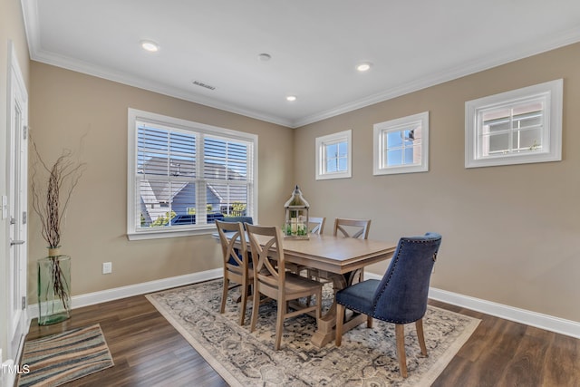 dining area with crown molding, baseboards, visible vents, and dark wood-style flooring