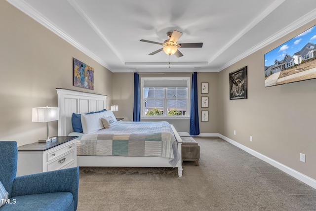 bedroom featuring a tray ceiling, carpet floors, baseboards, and crown molding