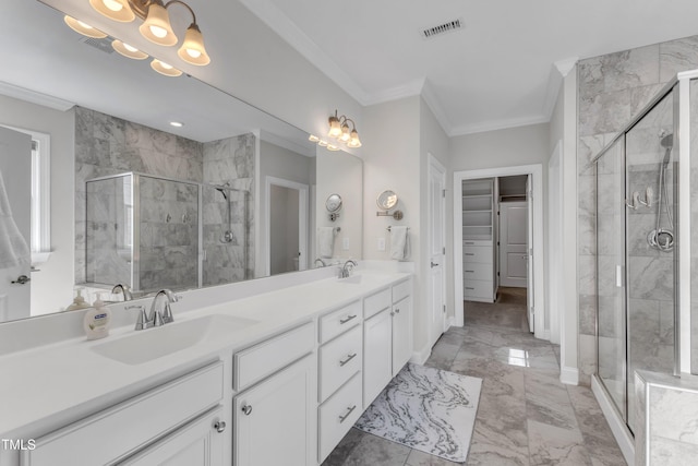 bathroom with marble finish floor, a shower stall, ornamental molding, and a sink