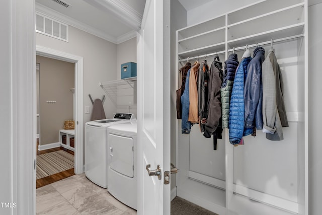 washroom featuring baseboards, visible vents, washing machine and clothes dryer, laundry area, and ornamental molding